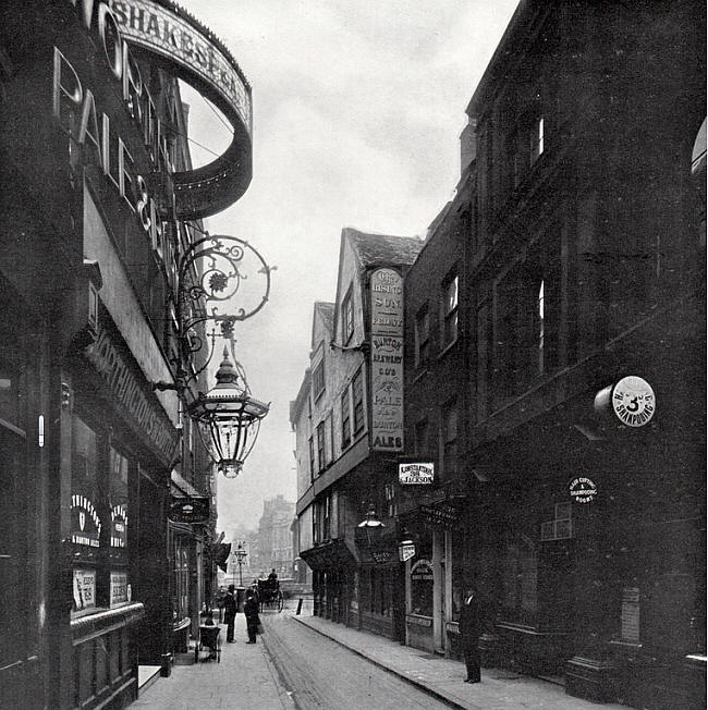 This shows the side of the Rising Sun (looking east down Wych Street) and on the left the Shakespear Head, 31 Wych Street.